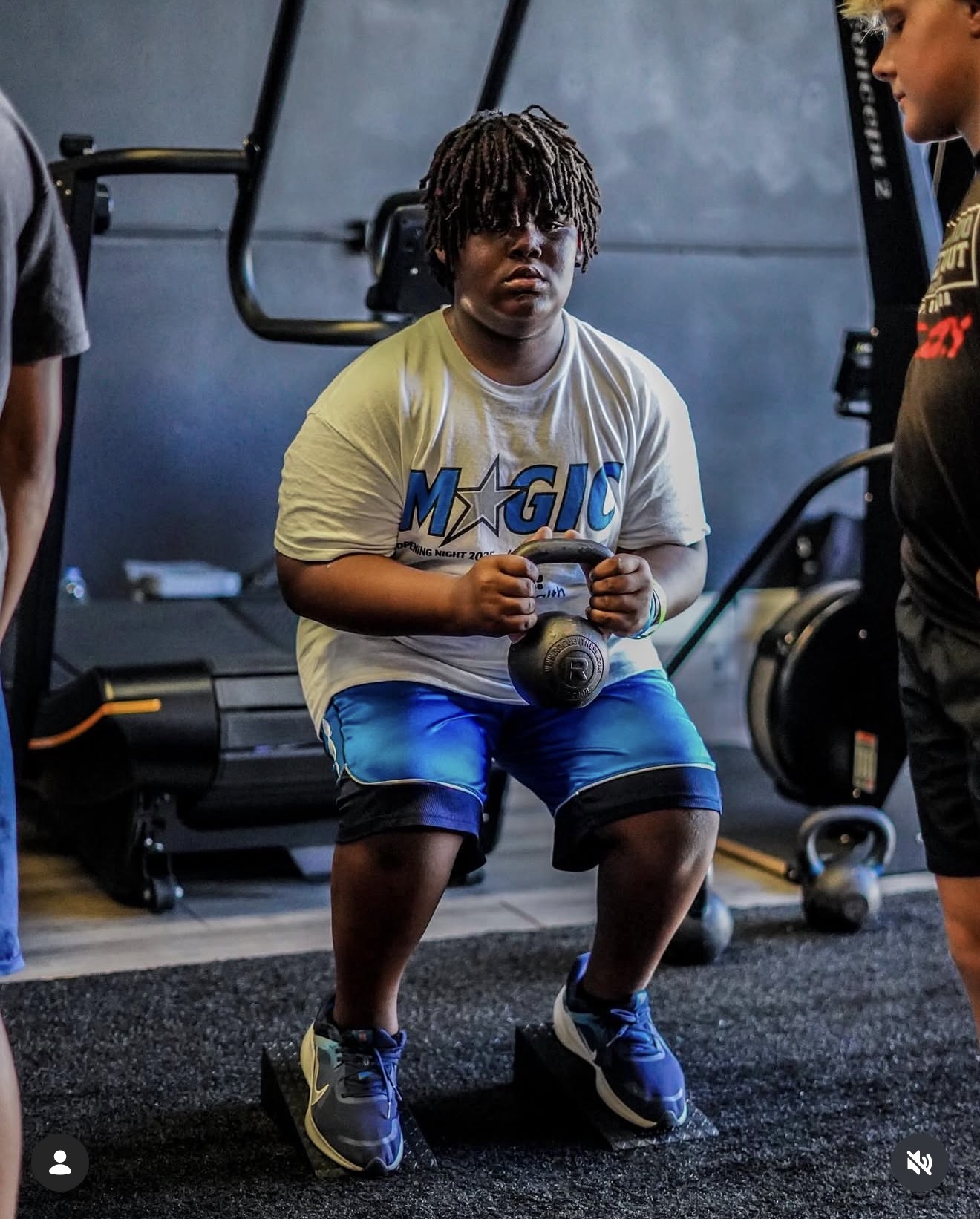 Young athlete performing a kettlebell squat during a session