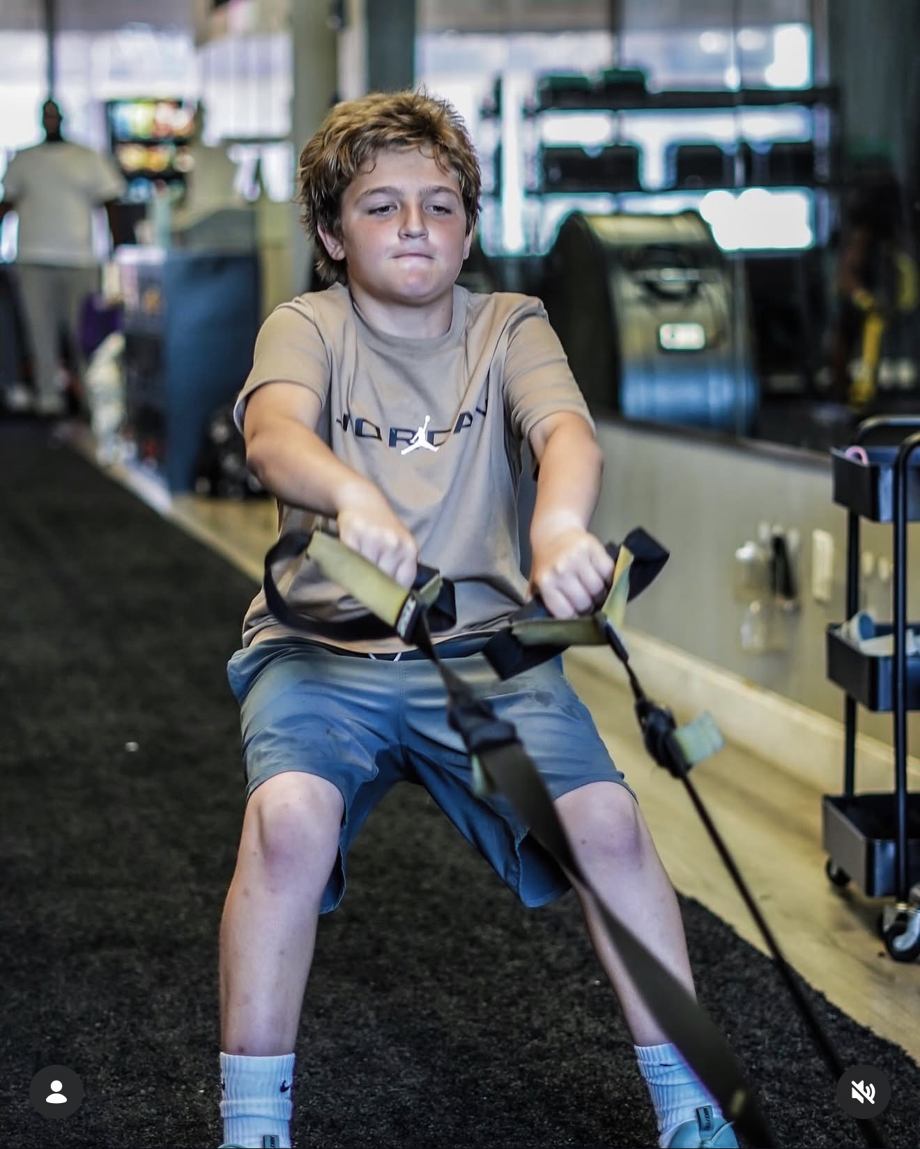 Boy pulling resistance bands during a strength circuit
