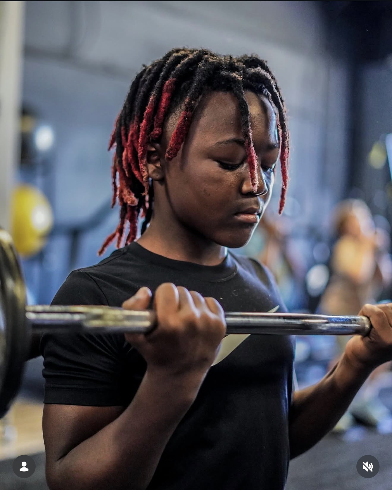 Young athlete focused on a barbell curl