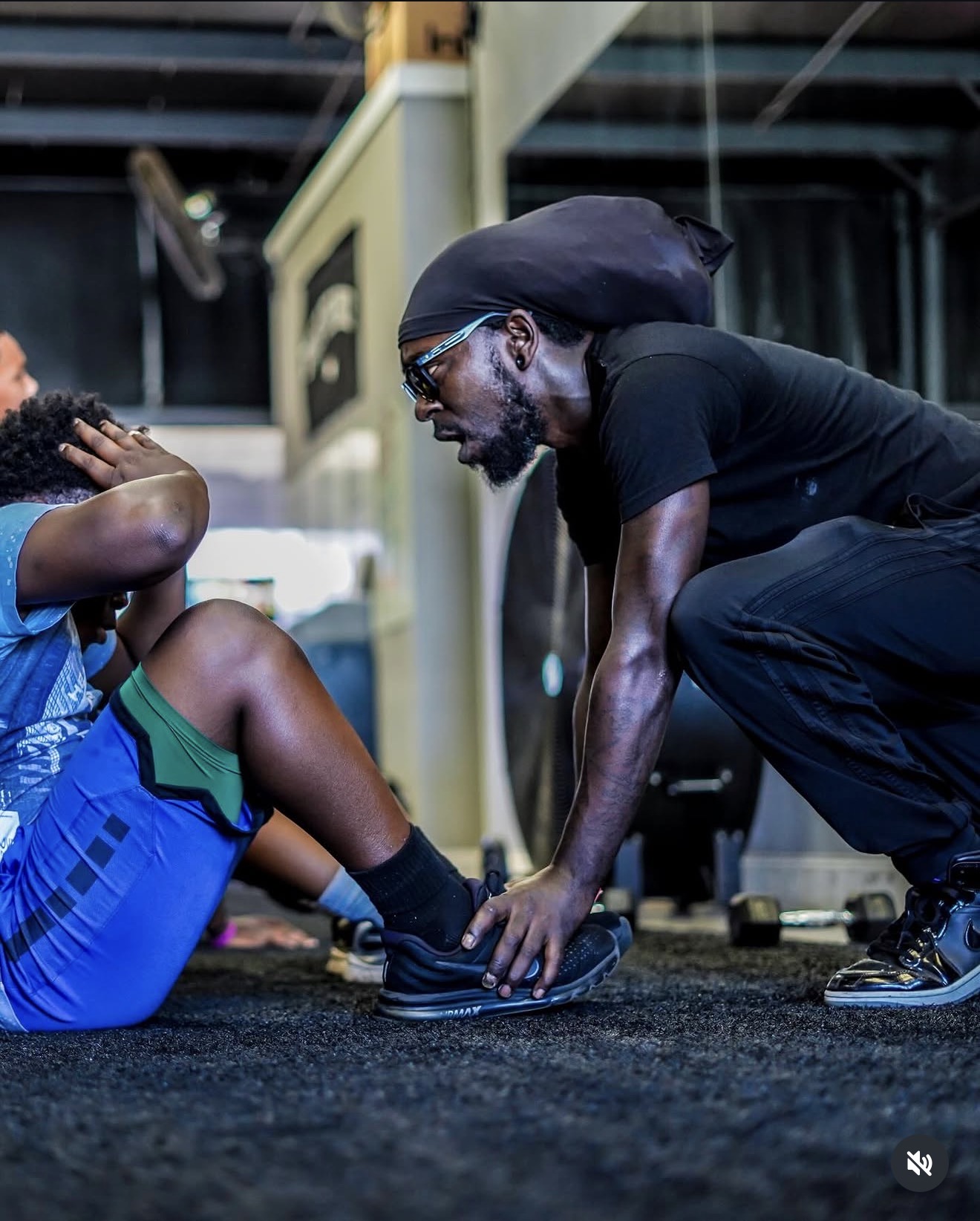 Coach holding a young athlete's feet during sit-ups